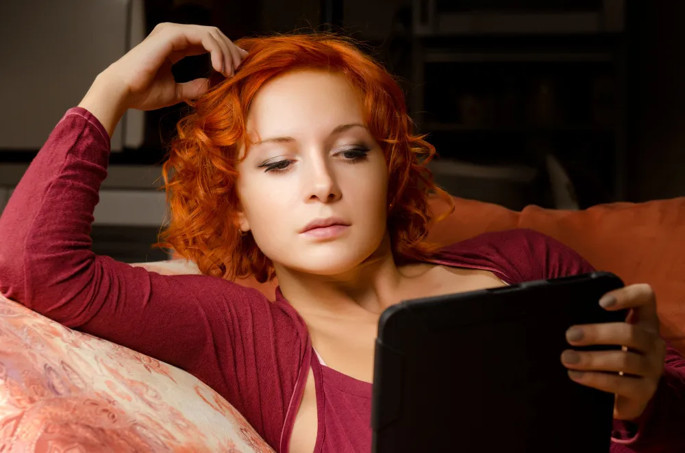 Content creator using TikTok on smartphone with engagement metrics and analytics dashboard showing growth strategy for OnlyFans promotion